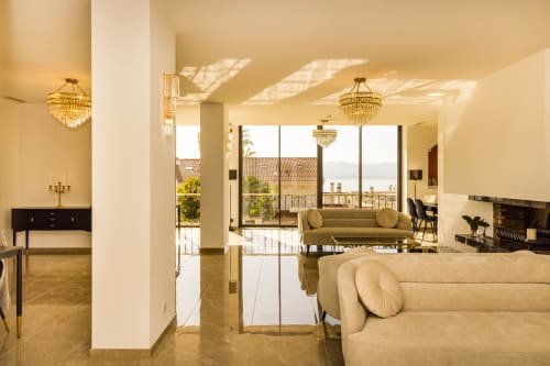 Luxury penthouse lounge at Hôtel Villa Martini in Ajaccio with chandeliers, cream sofas, and Mediterranean views