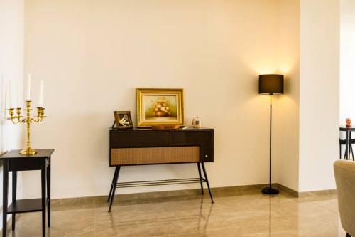 Elegant living room at Hôtel Villa Martini Ajaccio with mid-century furniture, golden candelabra, and modern floor lamp