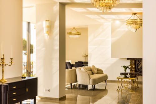 Hôtel Villa Martini's elegant Ajaccio lobby with cream armchair, crystal chandeliers, gold accents, and modern furnishings