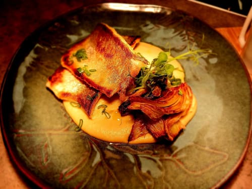Gourmet plated dish at Clos De La Gourmandiere B&B in Saint-Lothain, France, featuring seared fish with crispy skin and