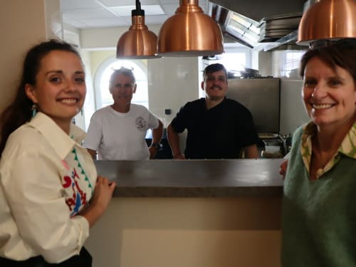 Staff smiling at Clos De La Gourmanderie kitchen counter, Saint-Lothain B&B
