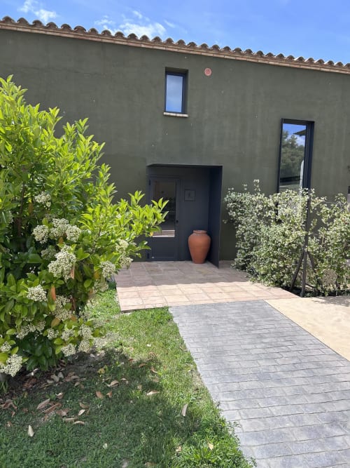 Entrada de l'hotel Mas Escarrà a Caldes de Malavella amb plantes florals i camí enrajolat