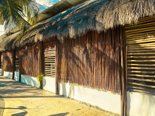 Bungalós con techo de palma y puertas de madera en el Hotel 40 Cañones, Mahahual, México