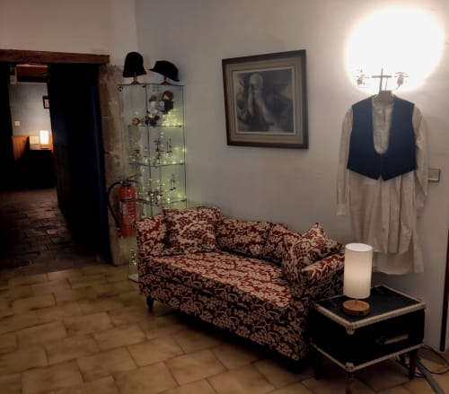 Museum display at Domaine de Cabrières B&B showing vintage couch, clothing, and artifacts in St Jean Du Gard