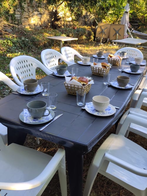 Table de petit-déjeuner en terrasse au Domaine de Cabrières, St Jean Du Gard, avec couverts et pâtisseries