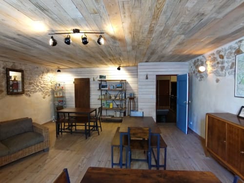 Spacieux espace commun ouvert au Domaine de Cabrières avec plafond en bois, tables de salle à manger, rangements et sièges à St Jean