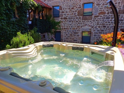 Baignoire à remous bouillonnante dans la cour en pierre des Gîtes Du Couvent, Nozières Ardèche