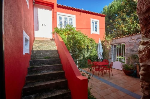 Pátio rústico com terraço vermelho vivo na SOTAM Country House, refúgio no interior português