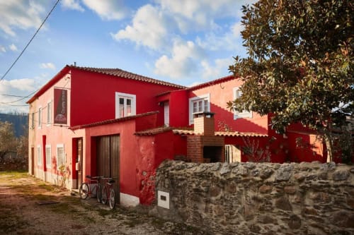 Villa vermelha com persianas brancas na SOTAM Country House, casa de hóspedes portuguesa com muros de pedra e vegetação