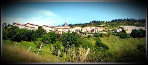 Village de Nozières sur les coteaux avec ses bâtiments traditionnels, vignobles et paysage verdoyant en Ardèche