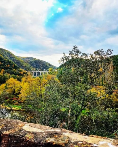 Vue pittoresque de la vallée des Gîtes Du Couvent avec viaduc, forêts verdoyantes et rivière en Ardèche