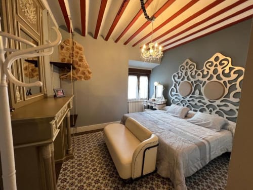 Elegante dormitorio en Complejo Turístico Retiro del Teatro con cabecero ornamentado, techo estriado y decoración clásica en Almagro