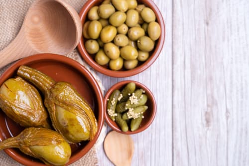 Assorted pickled vegetables and olives in terracotta bowls at Complejo Turístico Retiro del Teatro, Almagro