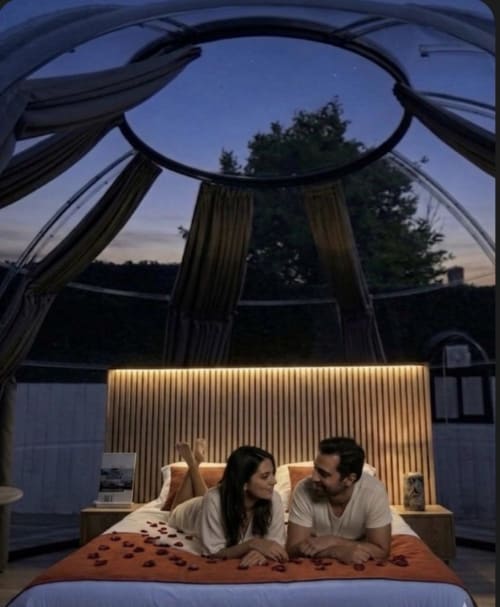Couple se relaxant dans un dôme bulle transparent avec vue sur le jardin à l'hôtel Bubble Jade, Bazouges la Pérouse, France