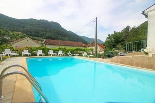 Serrana Gerês Inn swimming pool with mountain views, white loungers, and surrounding gardens in Gerês, Portugal