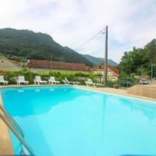 Outdoor swimming pool at Serrana Gerês Inn with mountain views and white loungers in Gerês, Portugal
