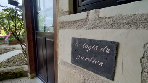 Plaque en ardoise « le logis du gardien » sur mur de pierre à l'entrée des Troglos de Beaulieu, Beaulieu-lès-Loches