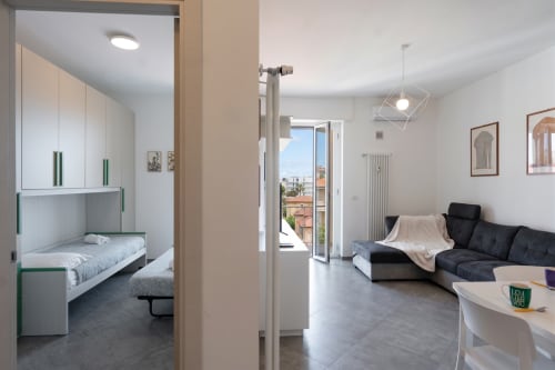 Appartamento Maestrale a Finale Ligure con zona giorno open-plan, camera con accenti verde, divano nero, balcone con vista mare