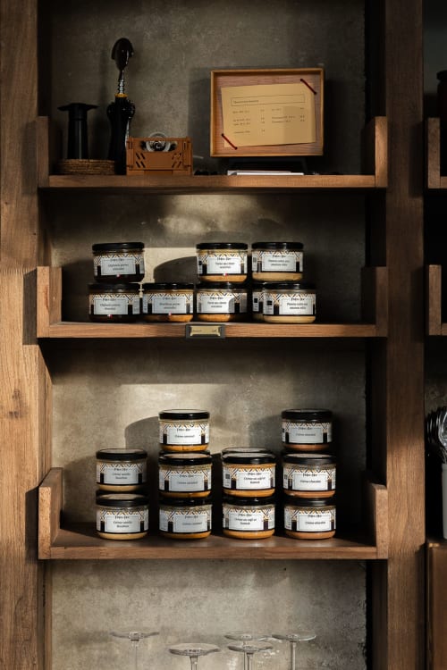 Étagère en bois de présentation au Moulin Moulin B&B à Dannes avec bocaux artisanaux, ustensiles de cuisine noirs et carte de recette encadrée