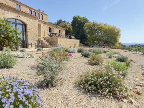 Exterior de Mimosa Lodge B&B a Montnegre, Espanya amb arquitectura de pedra, jardí i plantes mediterranies