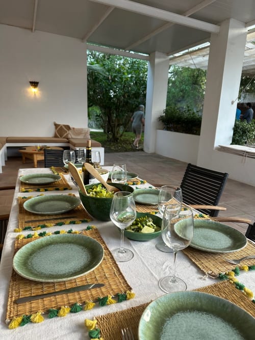 Salle à manger Slowvejer à Vejer de la Frontera avec table élégamment dressée, assiettes vertes, sets de table tressés et vue sur le jardin