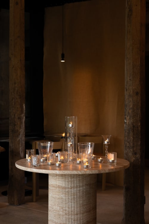 Table en bois épuré avec bougies allumées dans des photophores chez Moulin Moulin, une petite auberge à Dannes, France