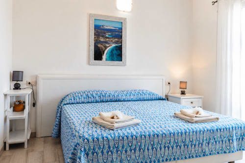 Helles Schlafzimmer im Molti Mari B&B in Murta Maria mit blauem Muster-Bettwäsche, Meereskunst und modernen Annehmlichkeiten