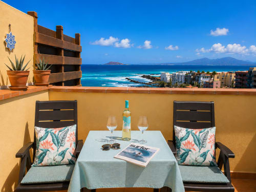 Terraza frente al océano en Sara & Gino Fuerteventura con vistas al mar, copas de vino y paisaje costero en Corralejo