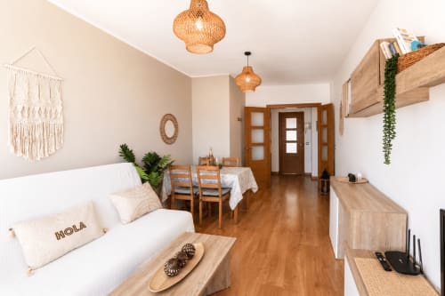 Modernes Wohnzimmer in Corralejo mit weißem Sofa, Esszimmer aus Holz, geflochtenen Pendelleuchten und Boho-Dekor