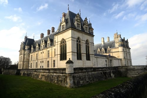 Majestueux château-hôtel historique aux tours ornementales et toit mansardé à Louvres, entouré de jardins impeccablement entretenus