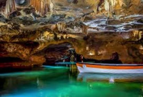 Coloridas barcas de pesca en aguas turquesas en una cala cueva cerca de Casa María, Artana, España