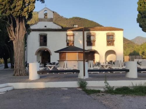 Patio de Casa María B&B en Artana, España con edificio blanco, zona de descanso con arcos y vistas a las montañas