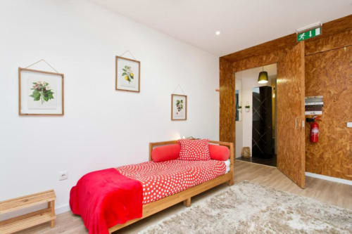 Bright Family Studio bedroom at Cem Contos Porto B&B with wooden bed, red polka dot bedding, cork walls, and botanical