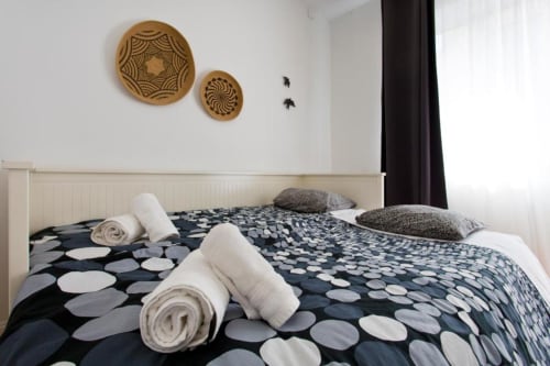 Family Room at Cem Contos Porto B&B with two beds, patterned bedding, rolled towels, and decorative woven wall art