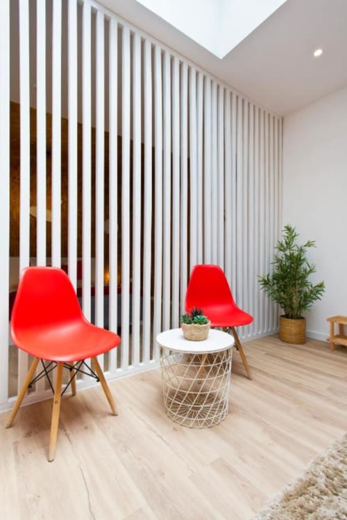 Modern Family Studio at Cem Contos Porto with red chairs, white vertical blinds, and natural light seating area