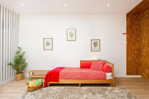 Bright Family Studio bedroom at Cem Contos B&B Porto with wooden bed, red polka dot bedding, botanical wall art, and hardwood