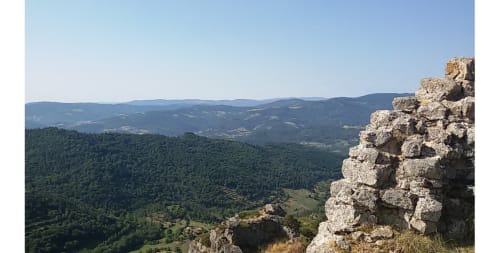 Ruines de pierre dominant une vallée boisée en Ardèche, France près des Gîtes Du Couvent