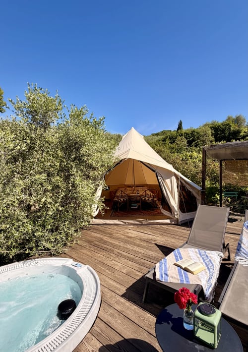 Tenda glamping con vasca idromassaggio su terrazza in legno presso Agritusmo Stecadò a Dolceacqua, circondata da ulivi