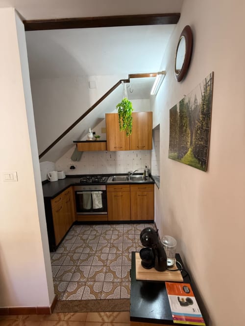 Moderna cucina nell'appartamento Tales of Abruzzo, Atessa Italia, con mobili in legno, fornello a gas e piante sospese