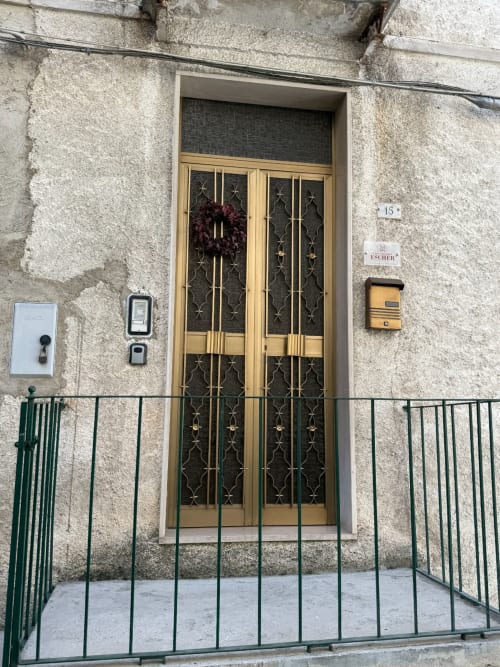 Ingresso dell'appartamento Casa Vacanza Escher ad Atessa con portone in legno, corona decorativa e cancello privato