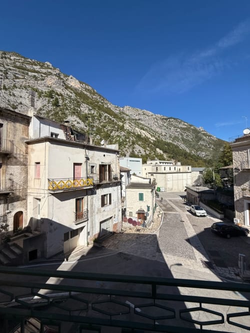 Edifici in pietra e corte nel villaggio di Atessa, appartamento Tales of Abruzzo con sfondo montano e cielo azzurro limpido