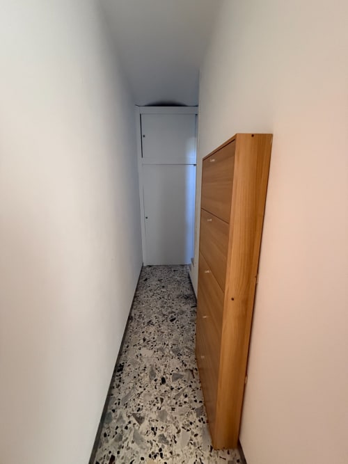 Stretto corridoio dell'appartamento Casa Vacanza Escher a Tales of Abruzzo, Atessa, con guardaroba in legno e pareti bianche