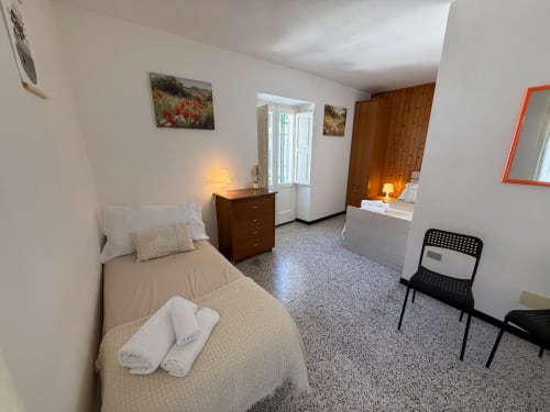 Ampia camera da letto a Casa Vacanza Escher ad Atessa con letto singolo, comò in legno e comfort moderni