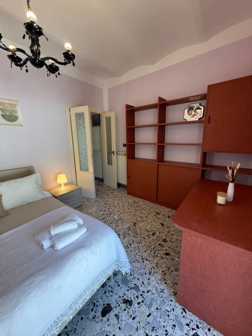 Ampia camera da letto a Casa Vacanza Escher ad Atessa con letto, scaffali in legno, scrivania in terracotta e pavimento moderno in terrazzo
