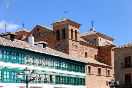Colonial architecture with turquoise colonial building and brick church, Almagro, Ciudad Real