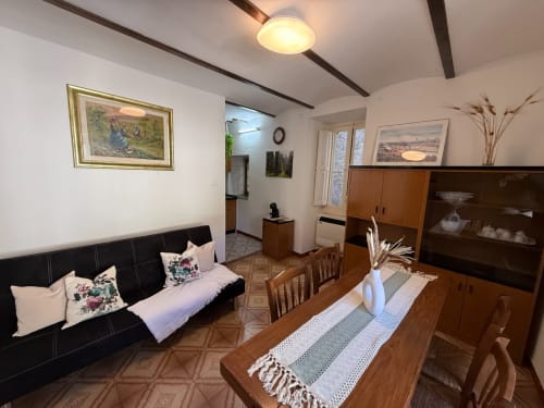 Accogliente salotto dell'hotel Tales of Abruzzo ad Atessa con divano nero, tavolo in legno e arredamento tradizionale