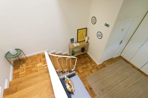 Chambre cosy du Cem Contos avec parquet, fauteuil vert, bureau blanc et décoration murale