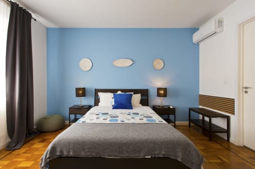 Chambre moderne au Cem Contos B&B Porto avec mur d'accent bleu, lit à structure noire et parquet