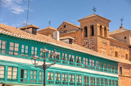 Turquoise colonial building with bell tower church in Almagro, Spain - Complejo Turístico Retiro del Teatro