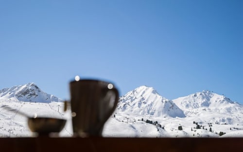Pics alpins enneigés vus à travers des vases sombres au Chalet des Cimes, Belle Plagne